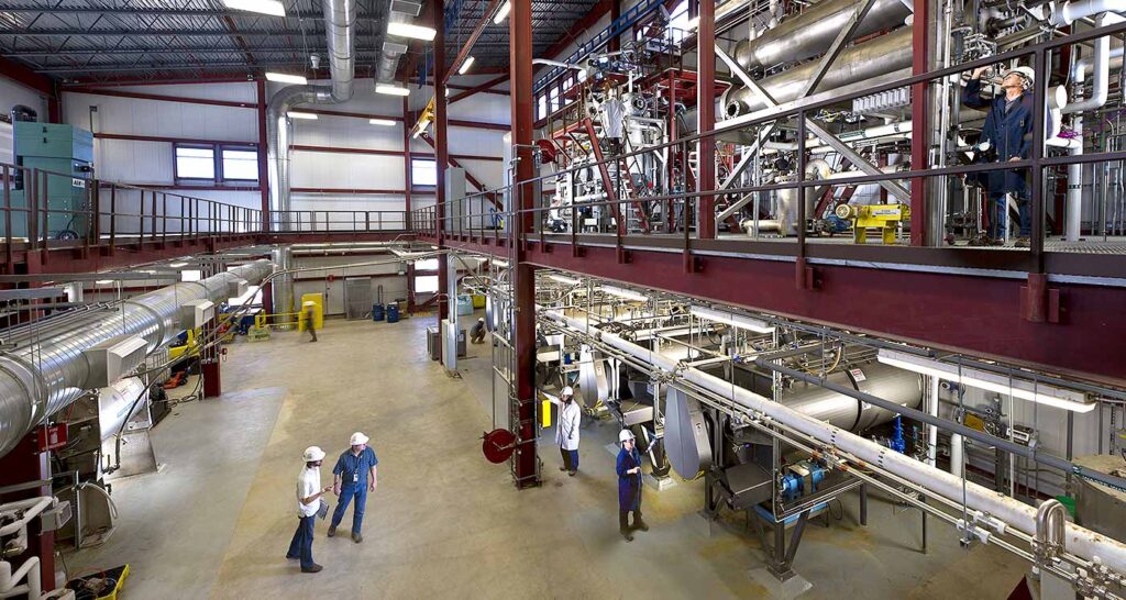 Pilot-scale biorefinery equipment with stainless steel process vessels, piping and elevated platforms.