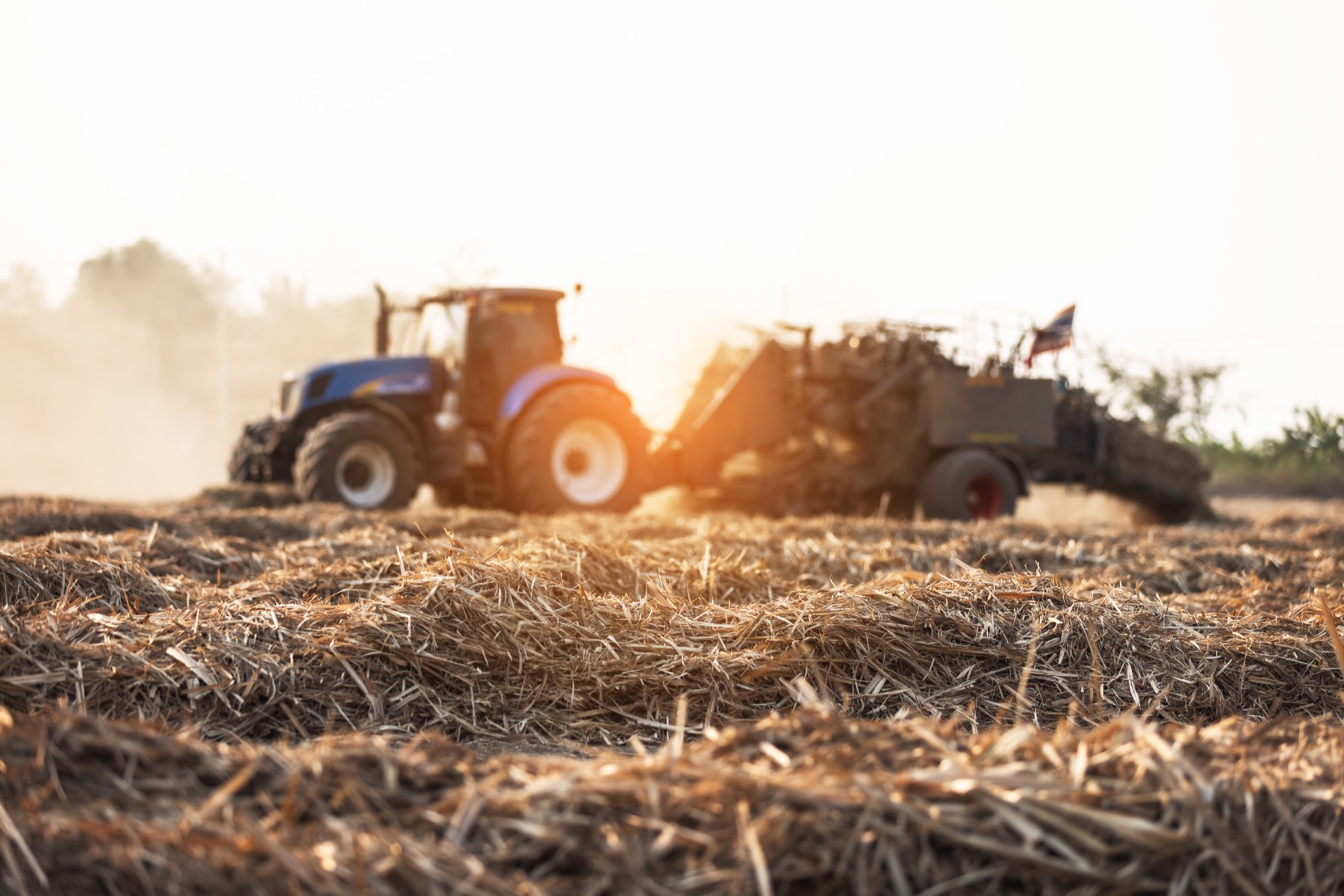 Tractor baling crop residues during feedstock collection operations
