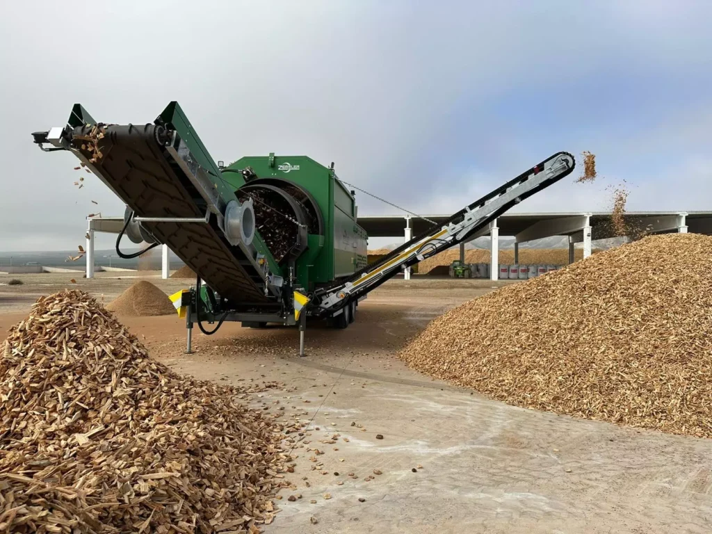 Biomass processing equipment with piles of wood chips at the Fuentes de Ebro facility in Zaragoza