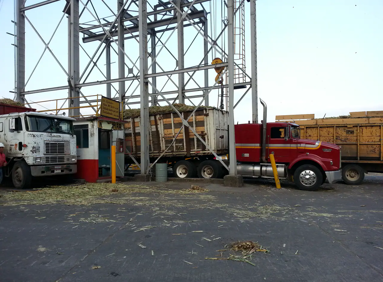 Loaded feedstock trucks arriving at an industrial plant reception area