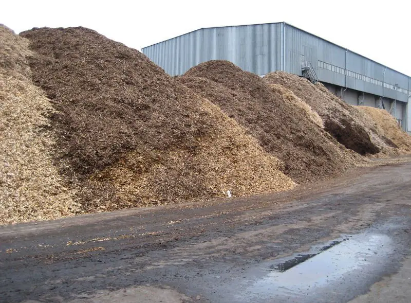 Large dry biomass stockpiles prepared for industrial handling
